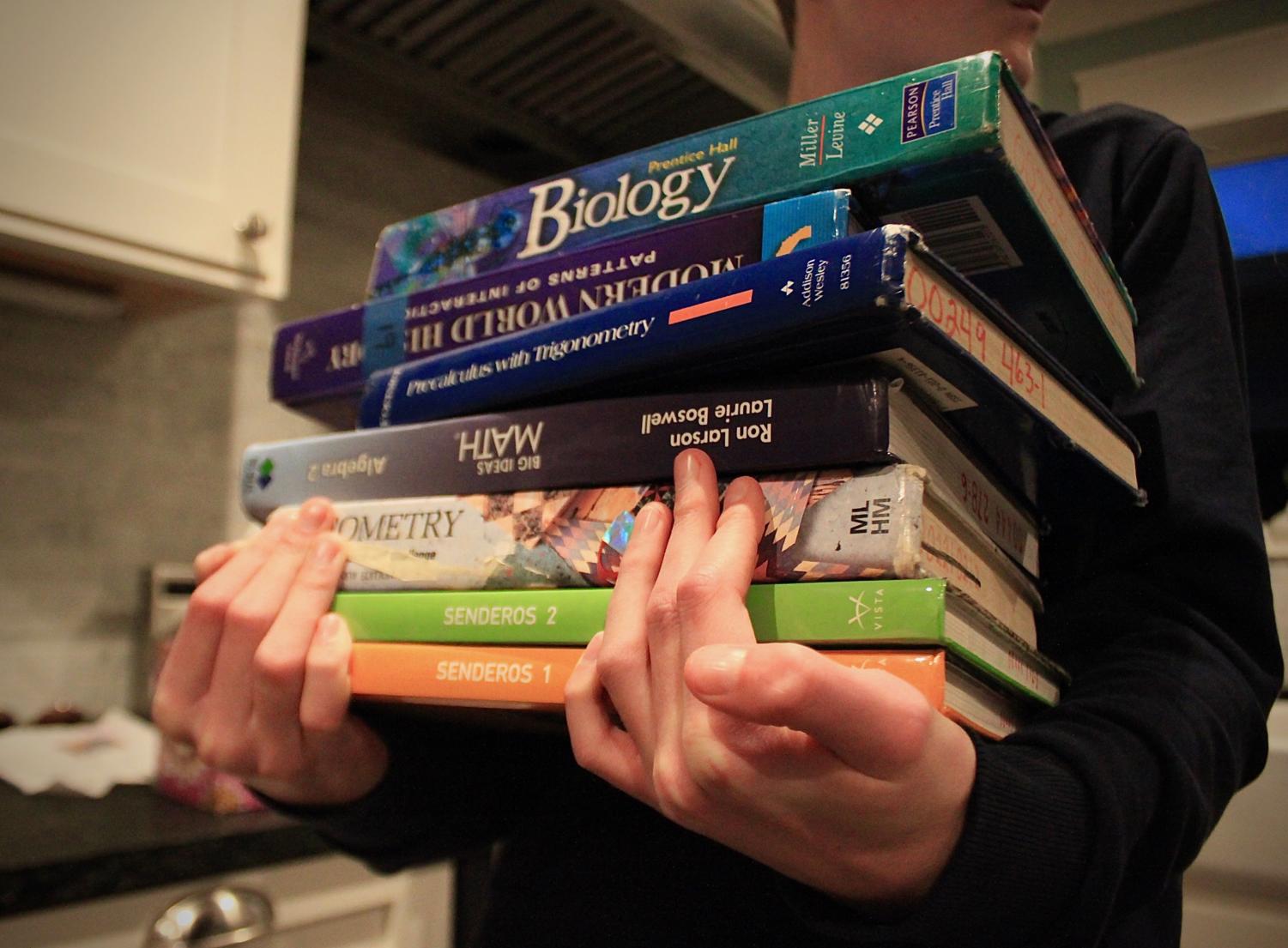 Carlmont student carrying a pile of textbooks